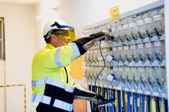Eine Elektrofachkraft arbeitet an einer Schaltanlage.  Das arbeiten an Umspannwerken, Mittelspannungsschaltanlagen oder Steuerstromkreisen, gehört zu den wesentlichen Tätigkeiten des Berufes.