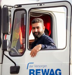 Mann der gerade in einen REWAG LKW einsteigt und dabei aus dem Fenster schaut.