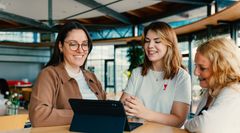3 Personen vor Tablet