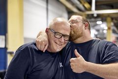 Zwei Männer stehen freundschaftlich zusammen in einer Werkshalle