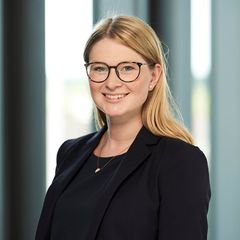 Porträtfoto einer lächelnden Frau mit Brille vor einem neutralen Hintergrund. Darunter ein Zitat: ‚Eine offene und vertrauensvolle Gesprächsatmosphäre auf Augenhöhe mit unseren Mitarbeitern, Bewerbern und Führungskräften ist mir besonders wichtig.‘ – Denise Jagiella, Personalreferentin.