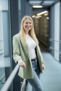 Porträtfoto einer lächelnden Frau mit Brille vor einem neutralen Hintergrund. Darunter ein Zitat: ‚Eine offene und vertrauensvolle Gesprächsatmosphäre auf Augenhöhe mit unseren Mitarbeitern, Bewerbern und Führungskräften ist mir besonders wichtig.‘ – Denise Jagiella, Personalreferentin.