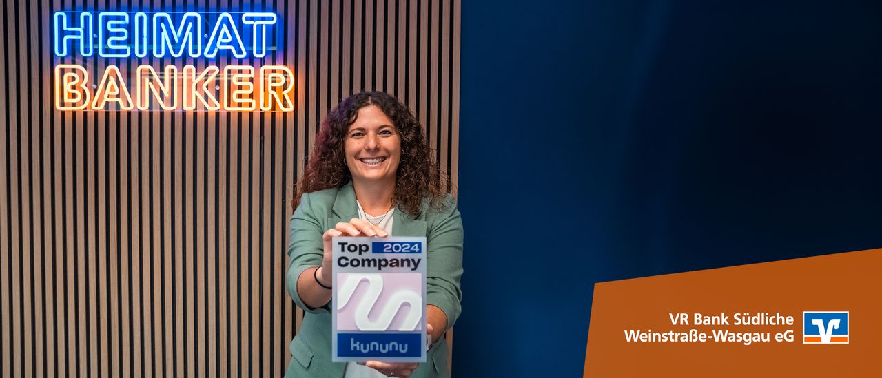 Frau hält Kununu-Siegel „Top Company 2024“ vor „HEIMAT-BANKER“-Leuchtschrift der VR Bank Südliche Weinstraße-Wasgau.