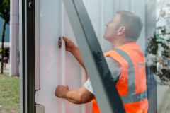 Service-Mitarbeiter bei Wall repariert eine Werbeanlage