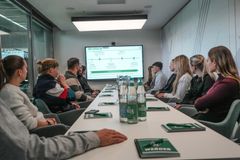 Die Neuzugänger*innen sitzen am Onboarding Tag zusammen und lauschen einer Präsentation