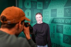 Ein Mitarbeiter fotografiert eine neue Kollegin für ein Mitarbeiterfoto