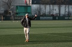 Greenkeeper läuft über Fußballplatz und zeigt Daumen nach oben