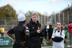 Mitarbeiterin gibt Spielerinnen Anweisungen